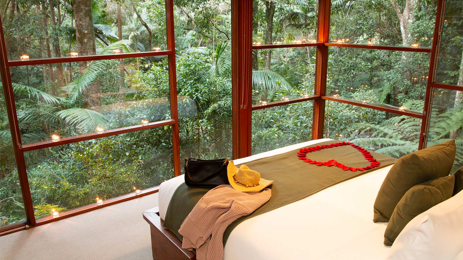 A lush rainforest view from the bedroom of a Creekside Spa Cabin